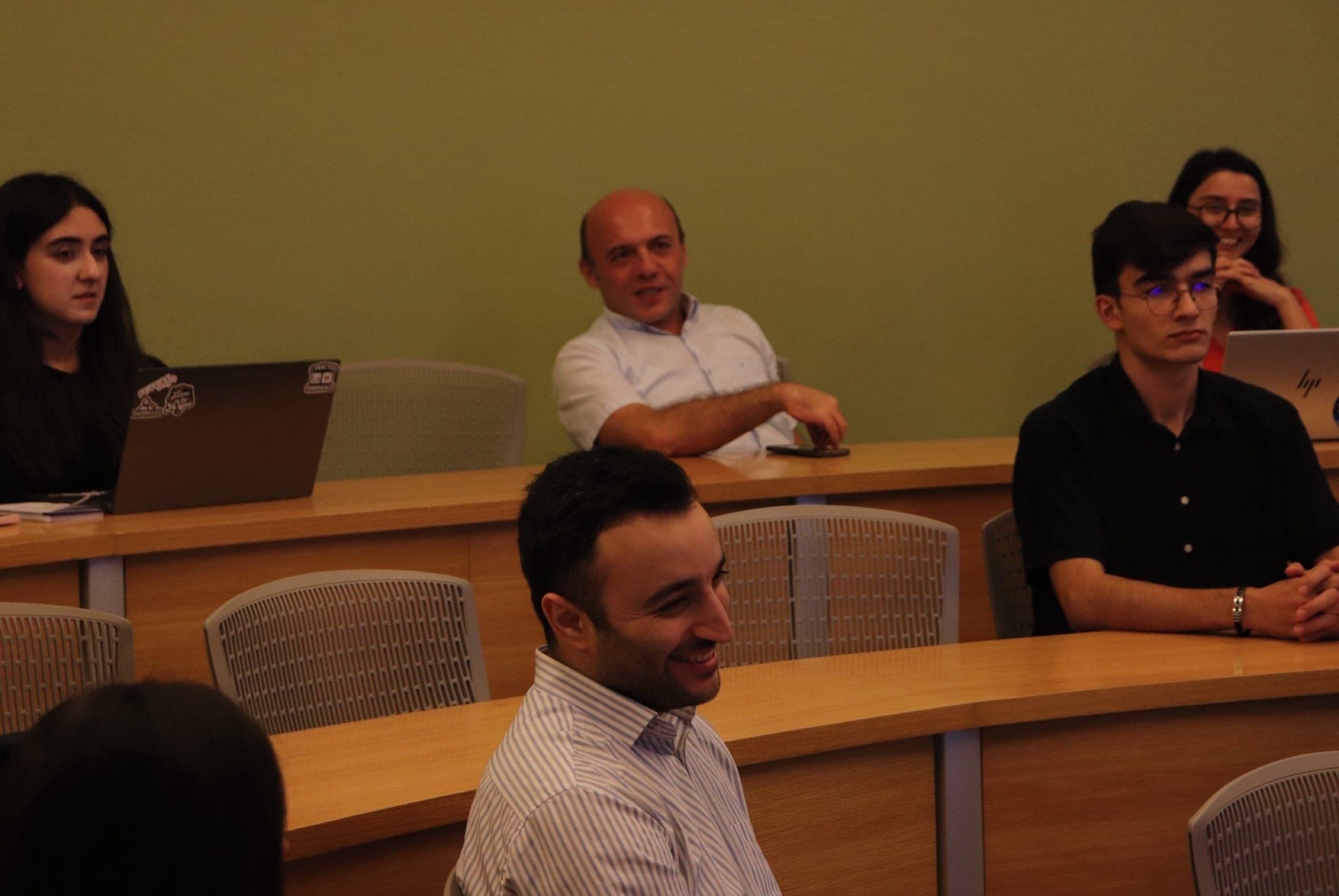 Attendees at the curved desks during the question period of the seminar.