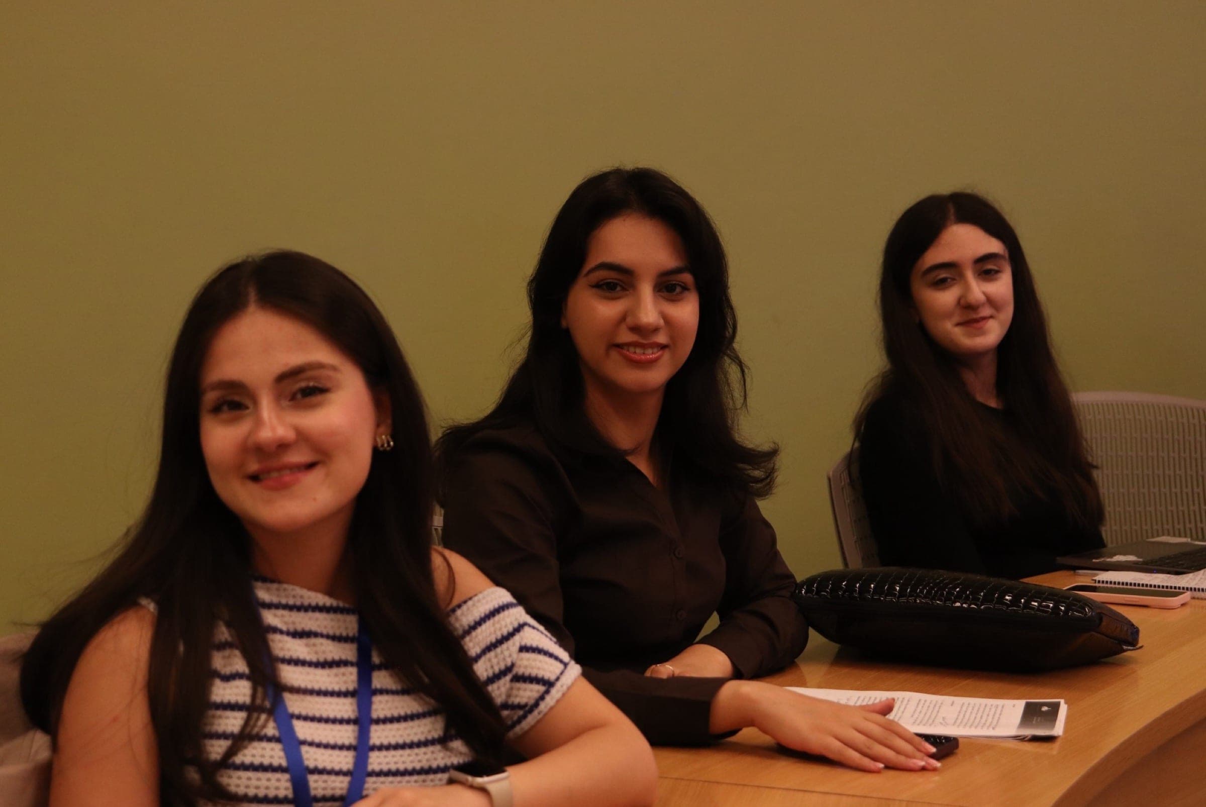 Three students seated together at the seminar desk.
